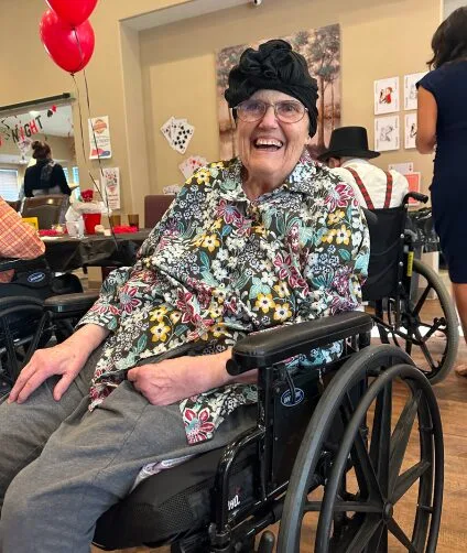 Laughing resident in a wheel chair | Aspen Creek Senior Living